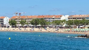 A coastal hotel with multiple balconies, a beach in the foreground, and a clear sky. - 4-person air-conditioned apartment with beach and all amenities within walking distance (Saint-Raphaël)