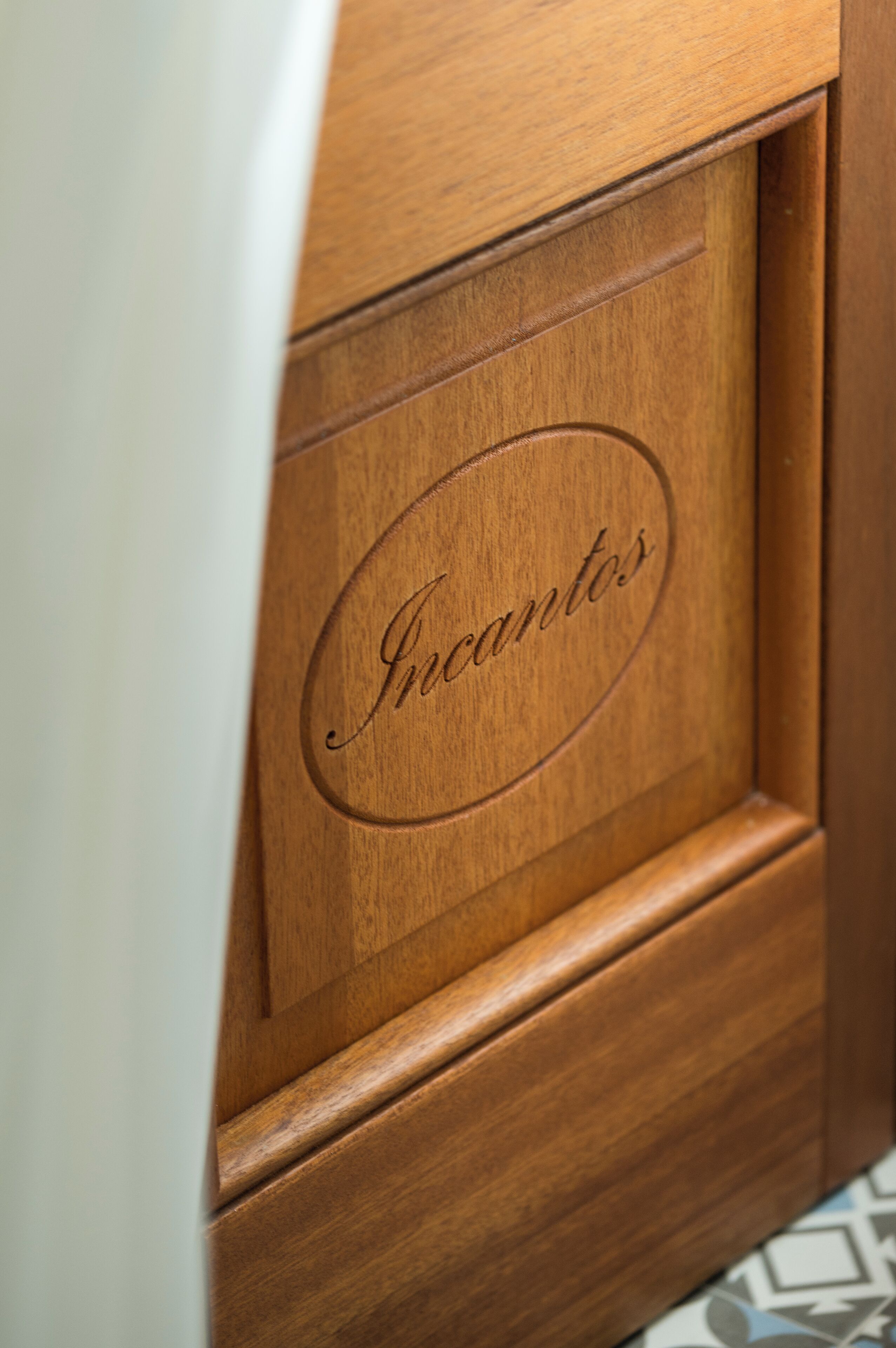 A wooden cabinet with the word "Incantos" engraved on it.