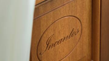 A wooden cabinet with the word "Incantos" engraved on it.