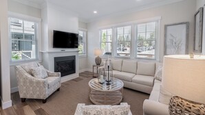 A living room with a fireplace, a television, a sofa, and a coffee table. - *New* Seabrook's Happy Place: Dog Friendly! (Pacific Beach)