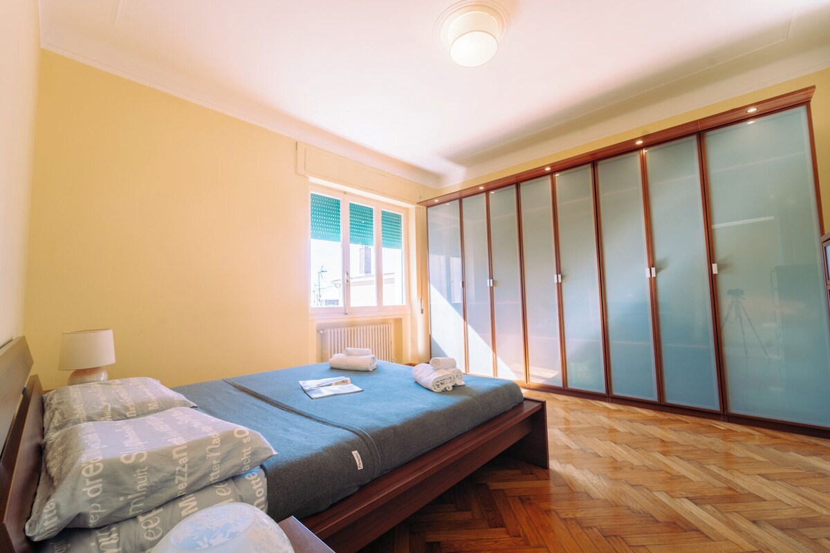Ein Schlafzimmer mit Bett, Fenster und Kleiderschrank.