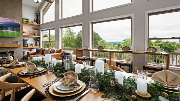 Un comedor con techo alto, ventanas grandes y vistas al exterior.