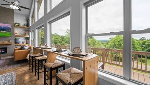 Una cocina amplia con ventanas grandes, una barra de madera y vistas al exterior.