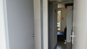 A hallway with a tiled floor, a door on the left, and a door on the right. - Sea view with no road to cross  (Leucate)