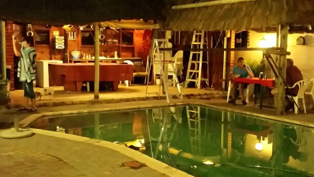 Ein Außenpoolbereich mit Bar und Sitzgelegenheiten.