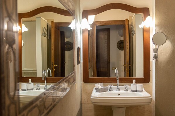 Un baño con dos lavamanos, un espejo y una ducha.
