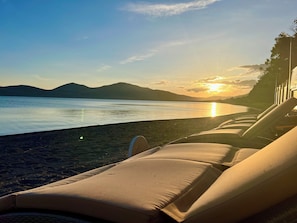 Privat strand, parasoller, strandhåndklær og sandvolleyball