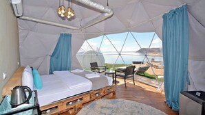 A spacious tent with a bed, a table, chairs, and a view of the landscape. - Comuna Sevan beach Glampings (Artanish)