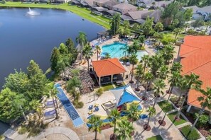 A resort with a swimming pool, palm trees, and a view of a lake. - 3br, 2.5ba Townhome W/ Lake View, Sunny Rear Yard 3 Bedroom Townhouse by RedAwning (Kissimmee)