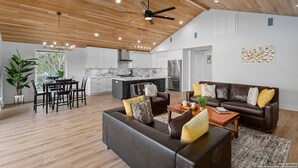 A spacious living area with a dining table, a sofa set, and a kitchen in the background. - Cl 874 Million Dollar View 5 Bedroom Home by RedAwning (Canyon Lake)