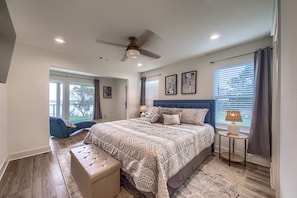 A bedroom with a large bed, a ceiling fan, a bedside table with a lamp, and a view of the outdoors through the window. - Cl 874 Million Dollar View 5 Bedroom Home by RedAwning (Canyon Lake)