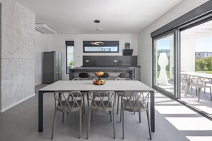 Enjoy meals in this spacious dining area with a large table and six chairs, offering a view of the outdoors.