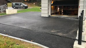 Un espace de stationnement avec un fourgon et l’entrée d’un bâtiment.