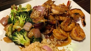 A plate of food with rice, vegetables, and shrimp. - Grand Palmac Hotel (Abuja)