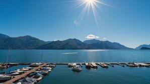 A marina with boats docked, surrounded by mountains and a clear sky.