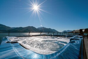 Relax in a hot tub on a deck with breathtaking mountain views.