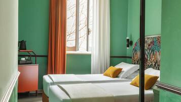 A room with a bed, a desk, a chair, a window with curtains, and a mirror.