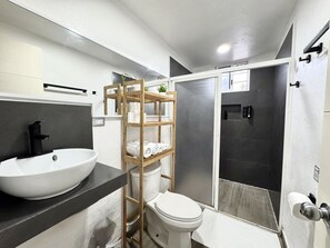 A modern bathroom with a white sink, toilet, and shower area. - La Perle Noire | AB - Terasse et Piscine (San Miguel de Cozumel)