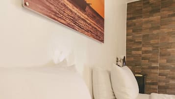 Ein Hotelzimmer mit Bett, Kissen, einem Wandbild und einer Wandverkleidung aus Holz.
