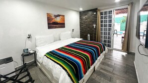 Een moderne hotelkamer met een groot bed, een klein nachtkastje, een stoel en uitzicht op het buitengebied.