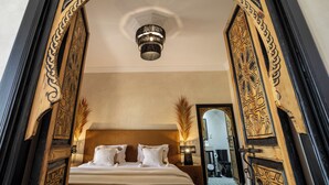 Una camera da letto con un letto grande, un lampadario e cornici in legno decorate.
