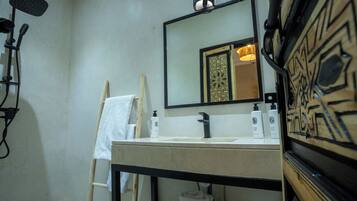 A bathroom with a sink, mirror, and towel rack.