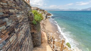 A stone staircase leading to a beach with a clear view of the sea and distant mountains. - Villetta Ficarazzi by Wonderful Italy (Ficarazzi)