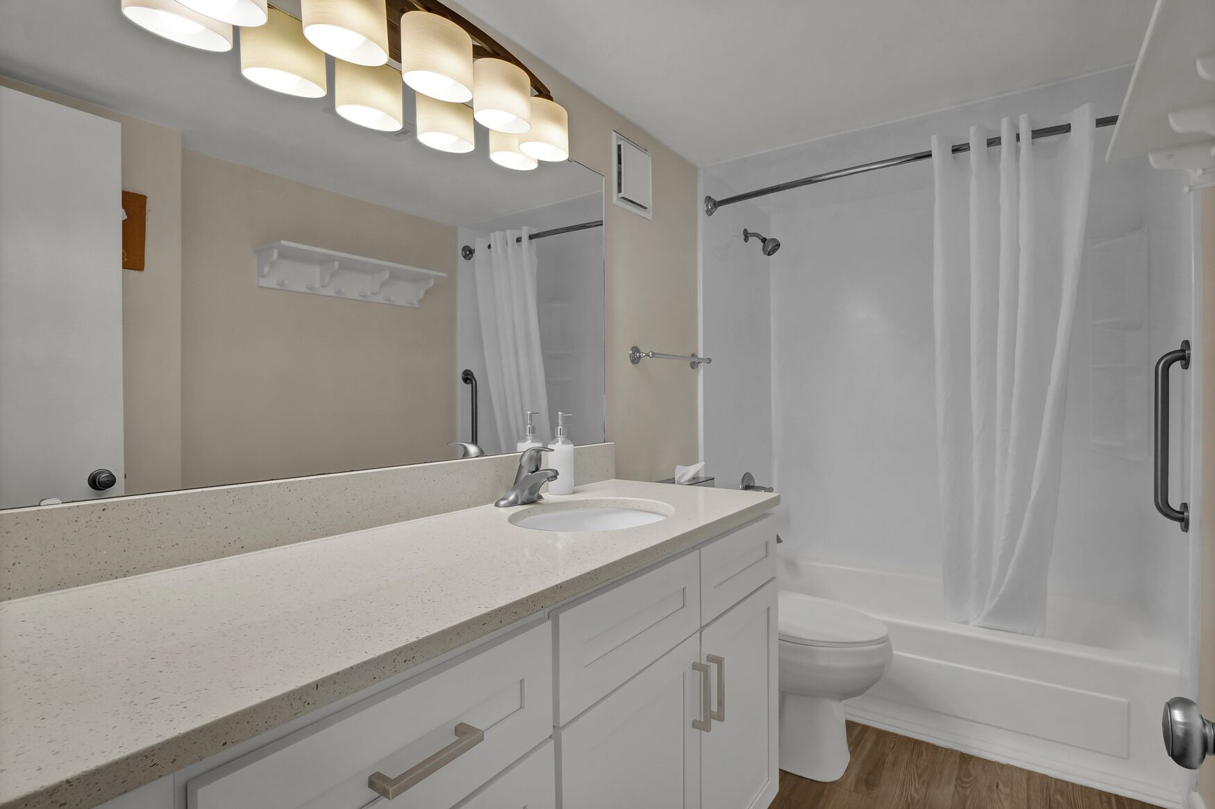 Une salle de bain moderne avec un grand miroir, un lavabo et une douche.