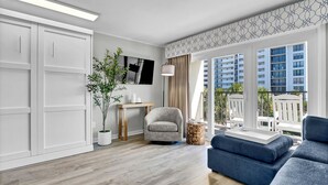 Una sala de estar moderna con un sofá, un sillón, una mesita y una planta en maceta.