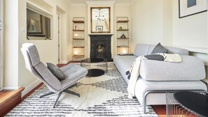 Una sala de estar con chimenea, un sofá, una silla y una mesa de centro.