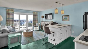 Un espacio habitable compacto con kitchenette, comedor y balcón con vistas.