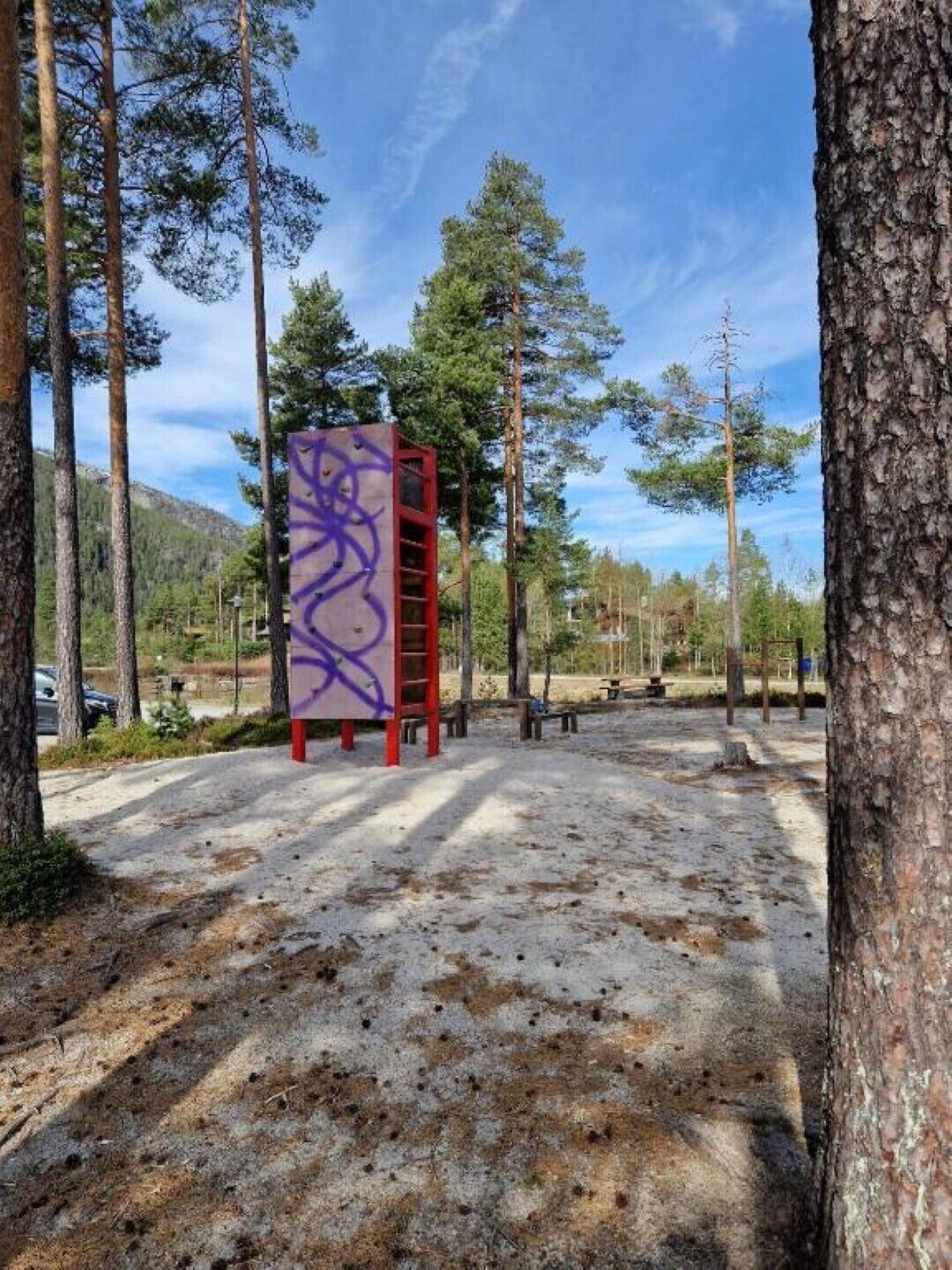 A concrete structure with graffiti, surrounded by trees and a clear sky.