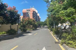 A residential street with a multi-story building, parked cars, and greenery. - JI Hotel (Xiamen SM Square Chenggong Avenue) (Xiamen)