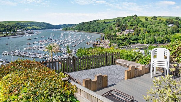 A marina with numerous boats docked, surrounded by lush greenery and hills. - 3 Bed in Kingswear (oc-a29168) (Dartmouth)