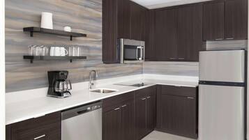 Una cocina moderna con armarios de madera oscura, electrodomésticos de acero inoxidable y una salpicadera de mármol.
