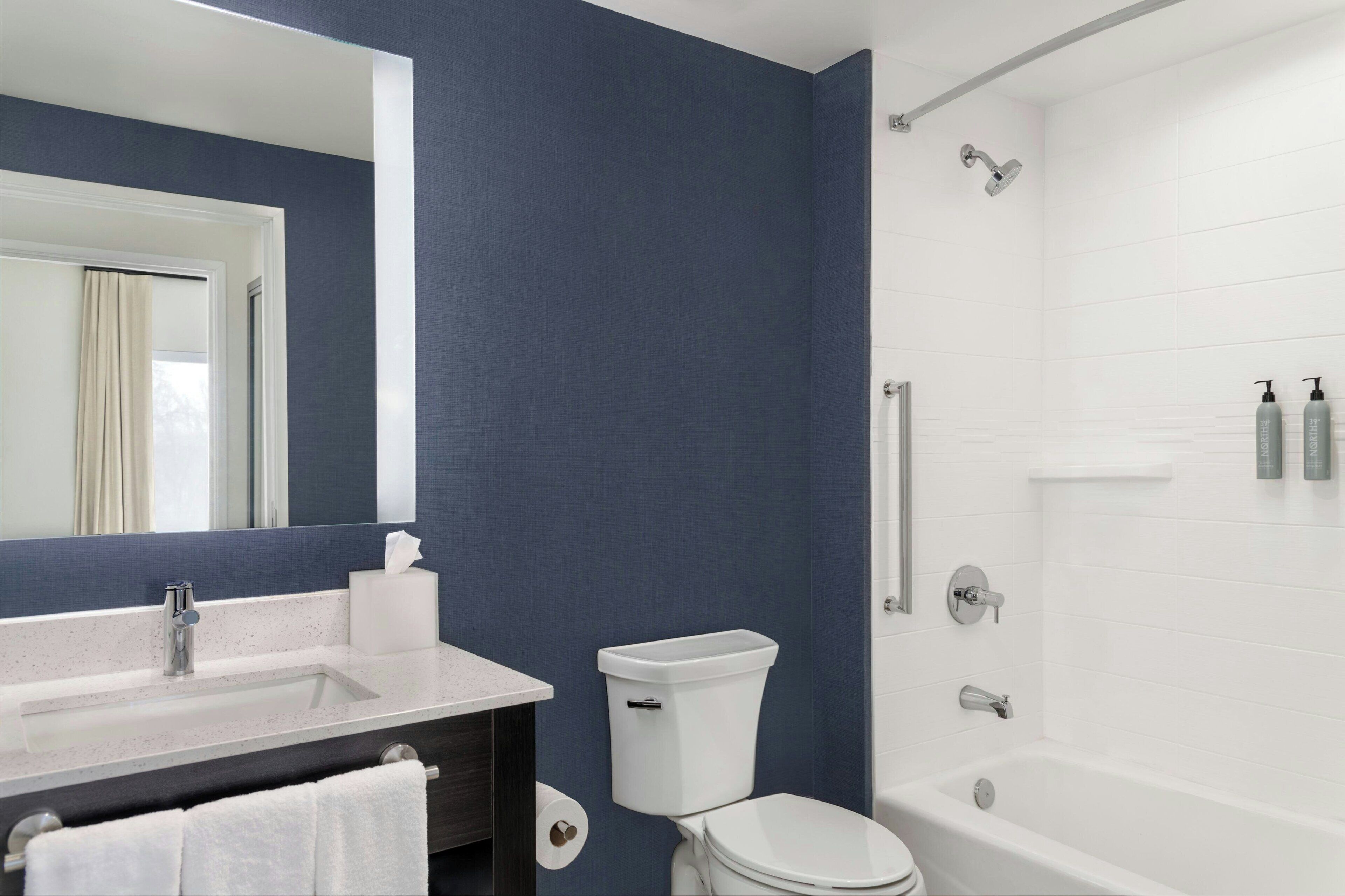 Un bany amb un lavabo, vàter i banyera blancs.