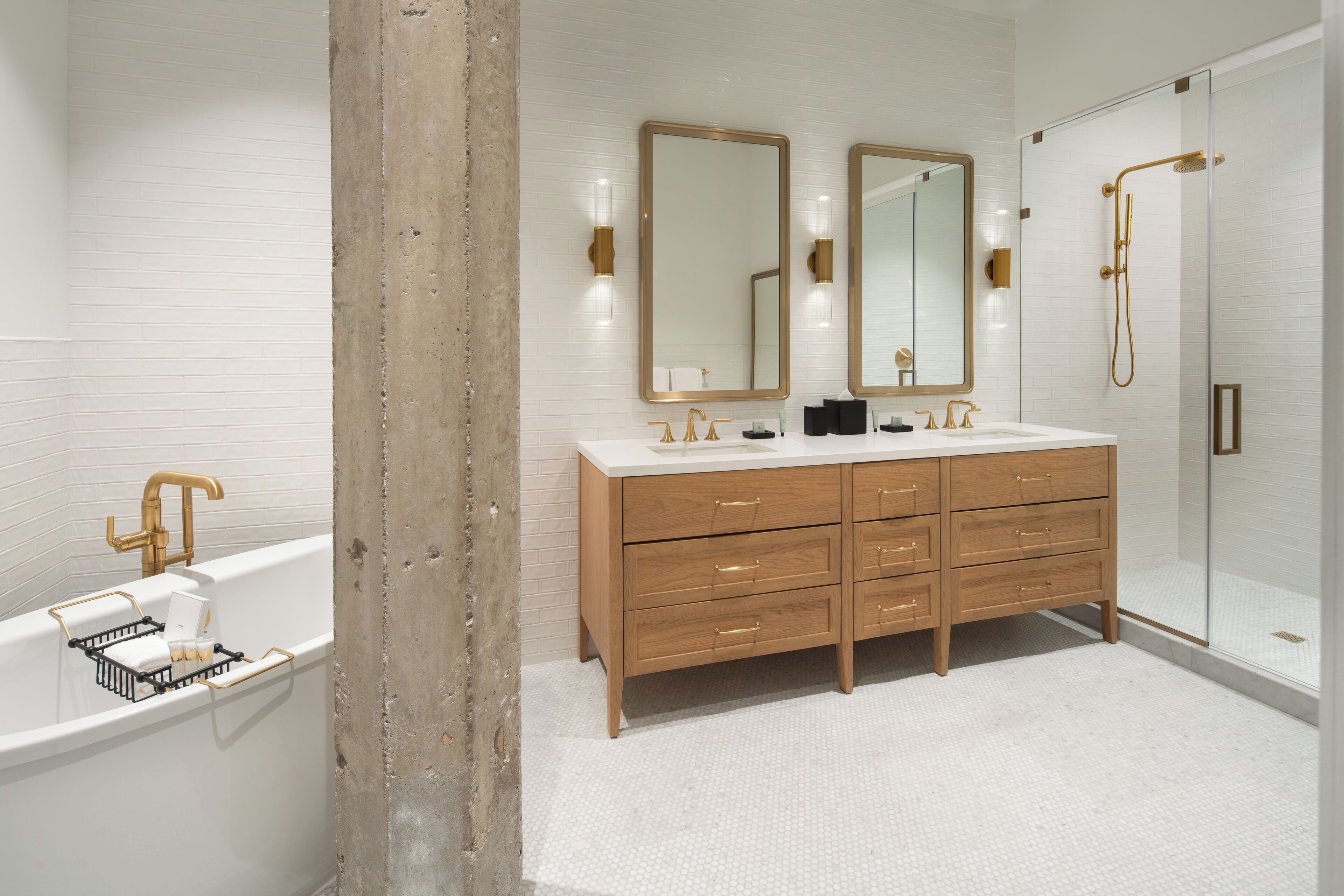 A modern bathroom with a double sink vanity, a bathtub, and a glass-enclosed shower.