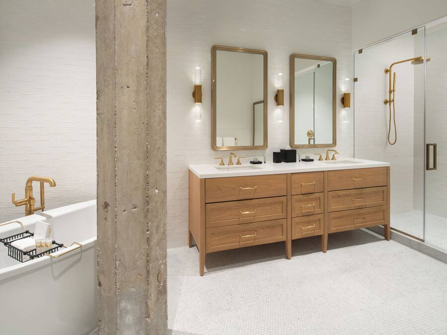 A modern bathroom with a double sink vanity, a bathtub, and a glass-enclosed shower.