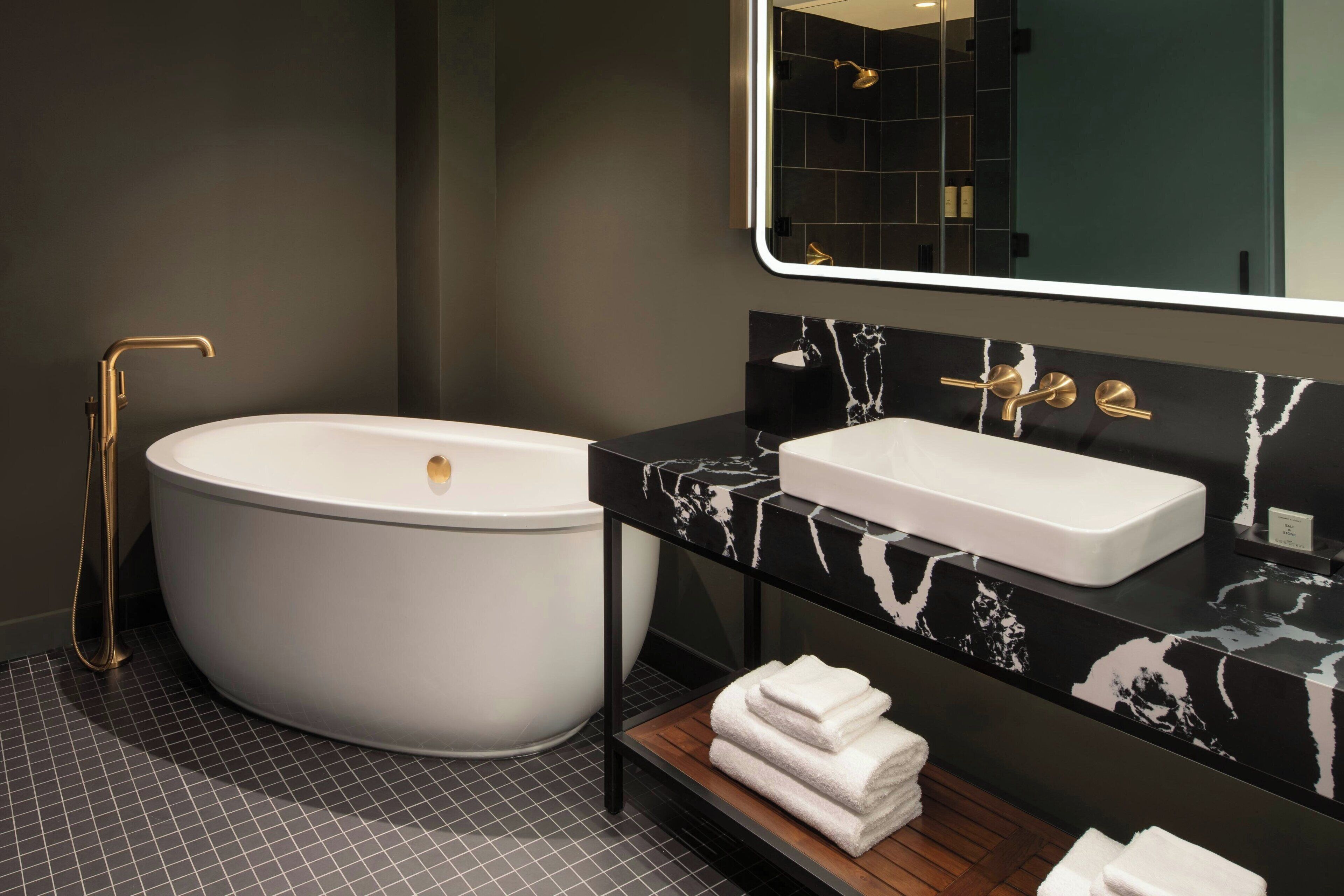 A modern bathroom with a freestanding bathtub, a vanity with a sink, and a mirror above the sink.
