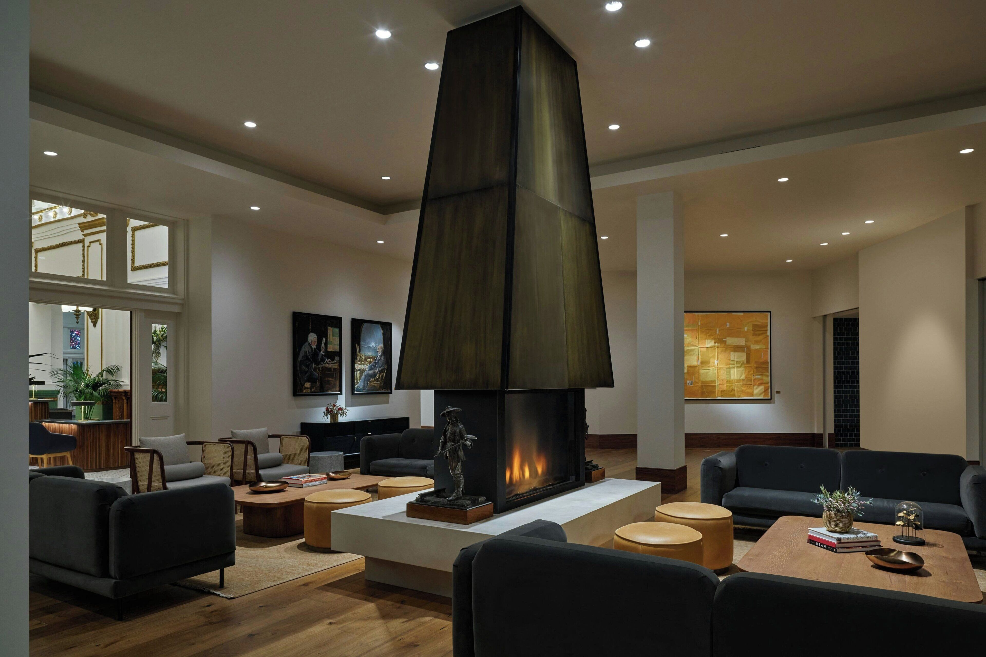 Una sala de estar moderna con una chimenea grande, asientos cómodos y un comedor.