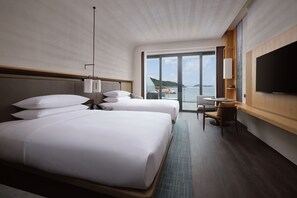 A hotel room with two beds, a desk, a chair, a TV, and a large window offering a view of the sea. - Zhuhai Dong'Ao Island Marriott Resort And Spa (Zhuhai)