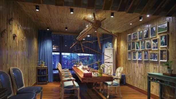 A wooden interior with a dining area, wooden walls, and framed pictures. - Manju Hotel (Kuantang) (Haining)