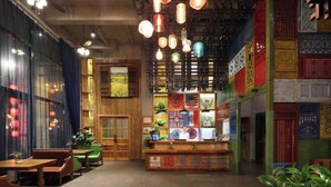 A restaurant interior with wooden furniture, hanging lights, and colorful decorations. - Manju Hotel (Kuantang) (Haining)