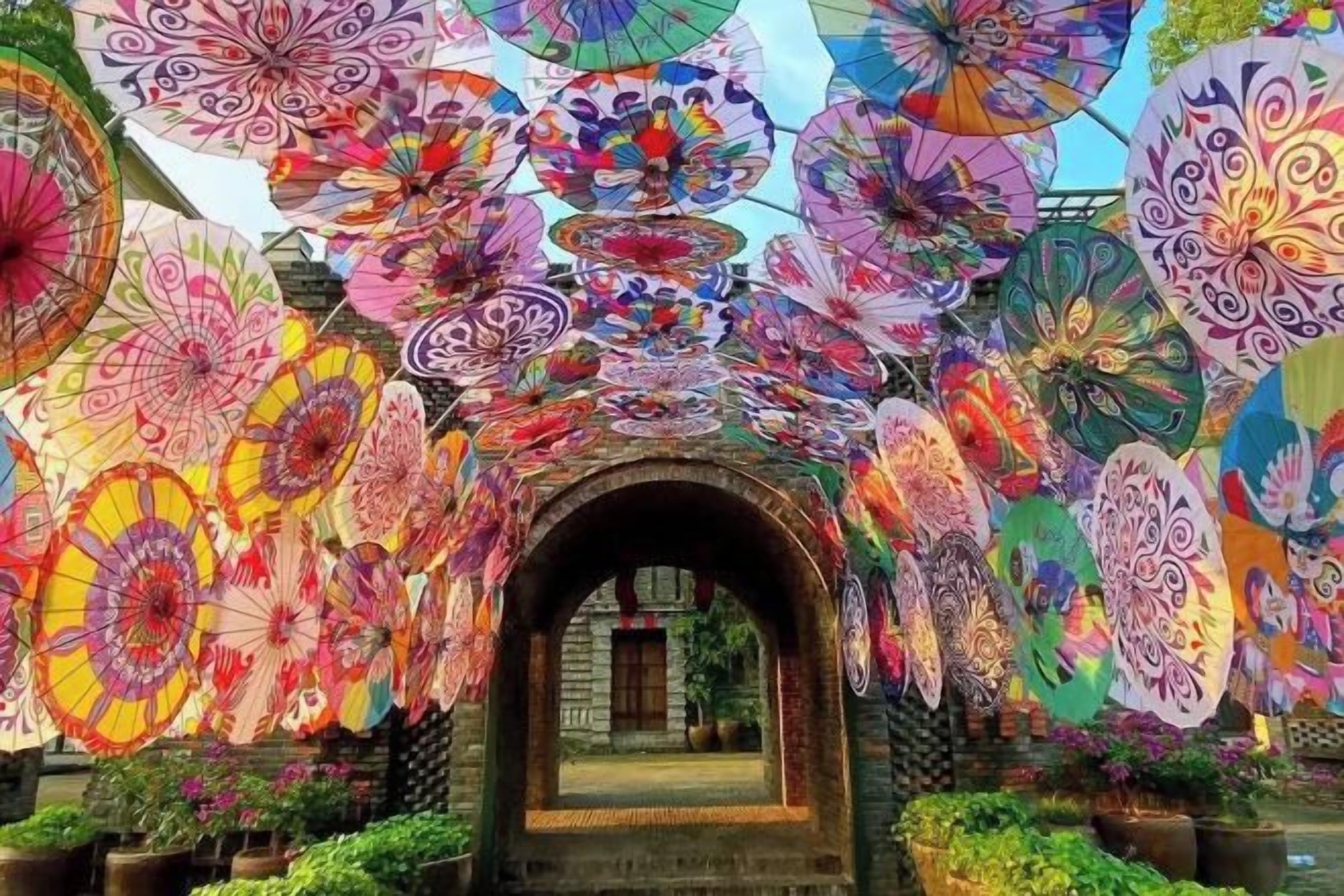 An archway with colorful umbrellas overhead.
