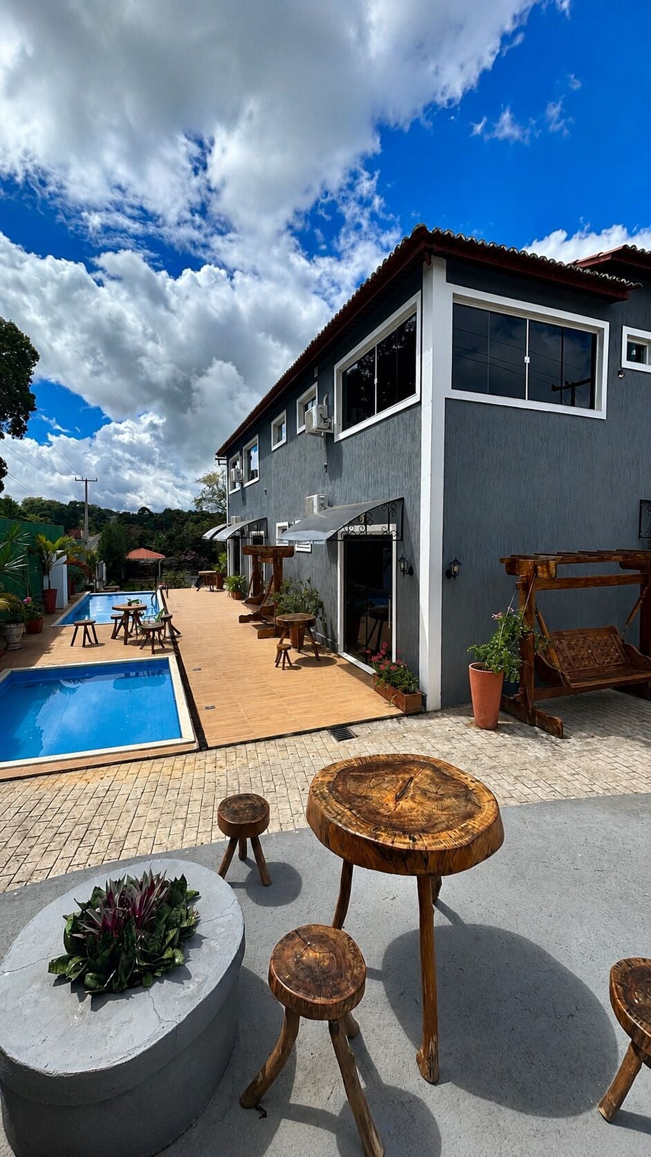 A modern house with a swimming pool, outdoor seating, and a patio area.