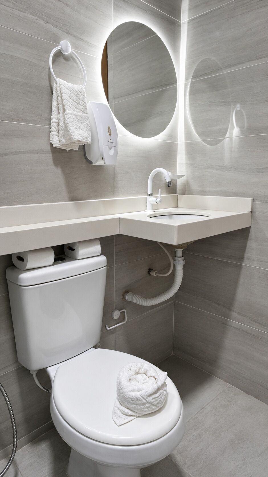Une salle de bain moderne équipée de toilettes, d’un lavabo et d’un miroir.