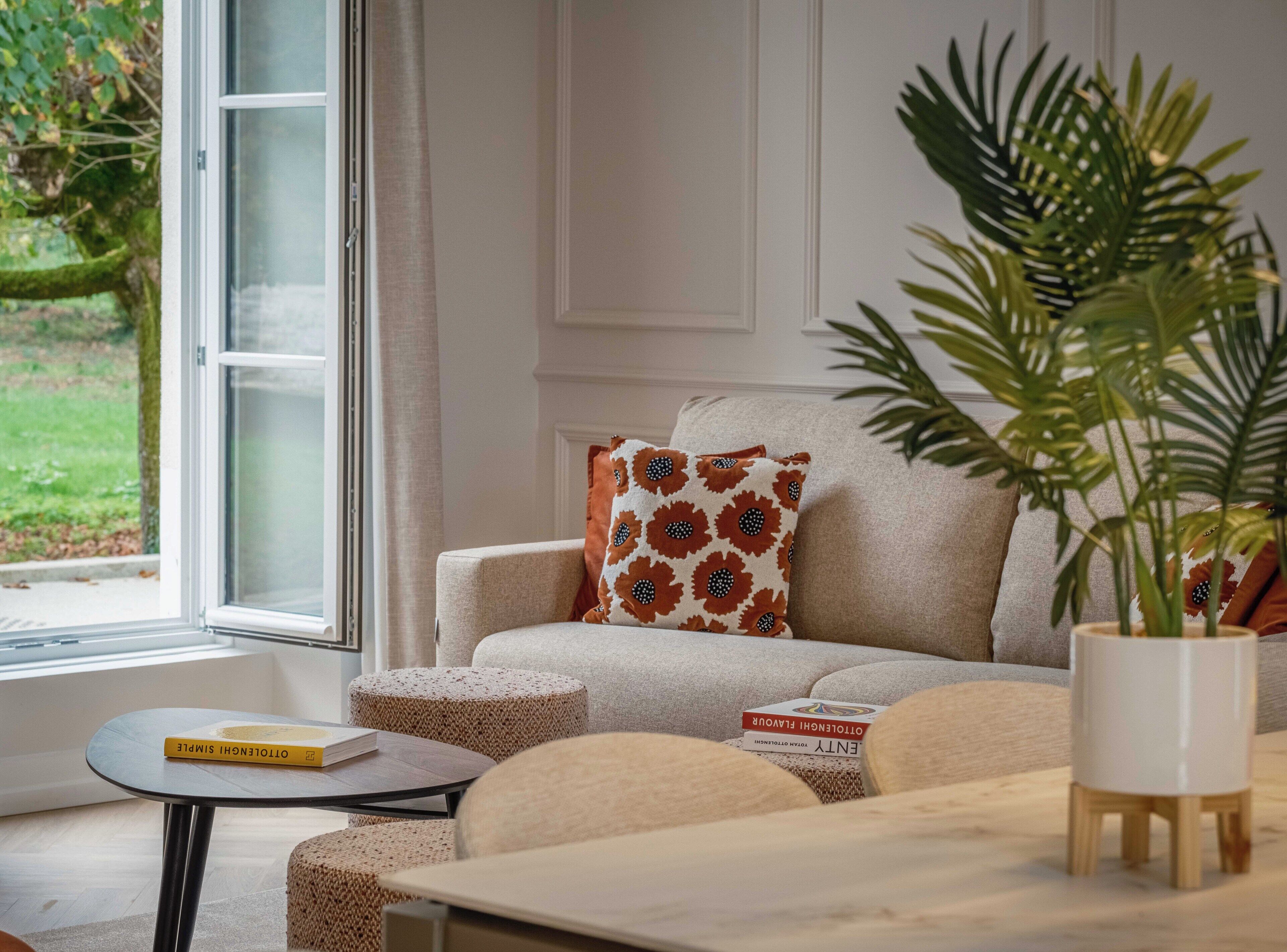 Un salon avec un canapé, une table basse et une plante en pot.
