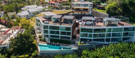 A modern hotel with a rooftop pool and multiple floors.