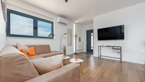Una sala de estar moderna con un sofá, un televisor y una mesa de centro.
