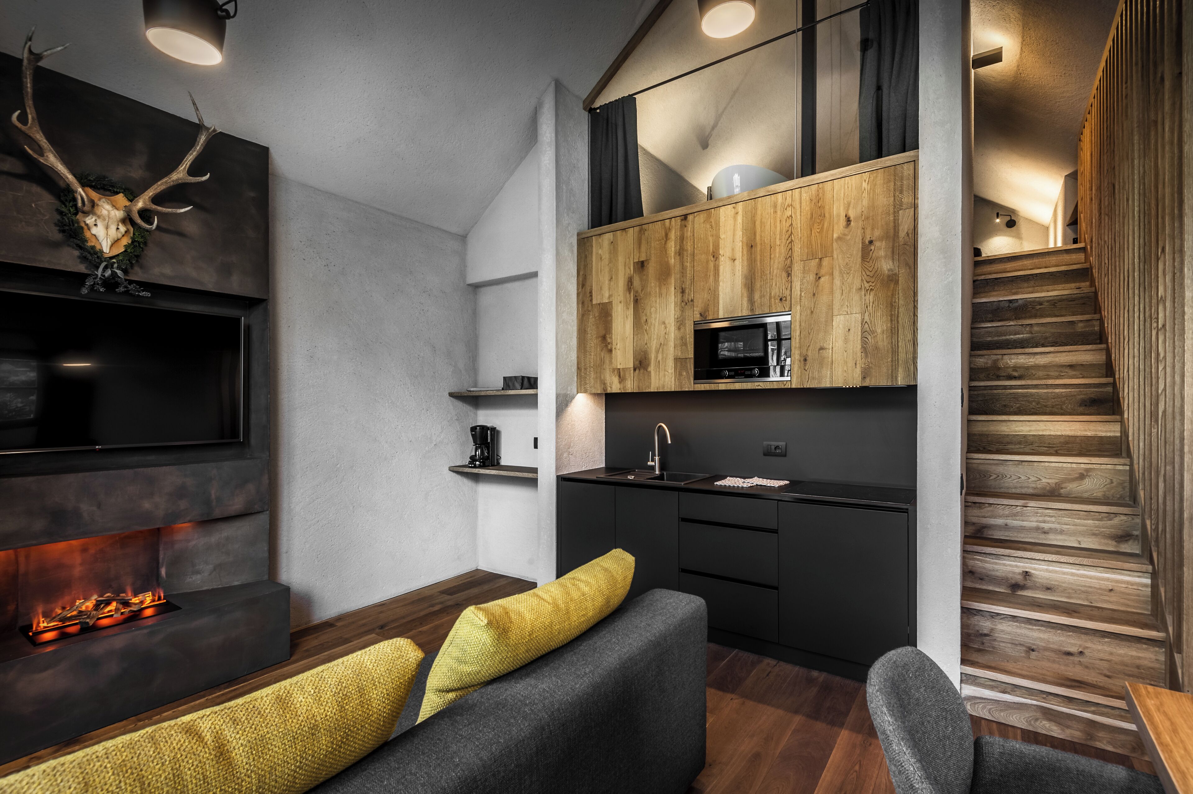 Una cocina moderna con microondas integrado, un armario de madera y una encimera negra.